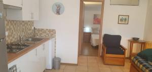 una cucina con lavandino e sedia in una stanza di Vivenda Maresol a Sagres Altre 44 foto