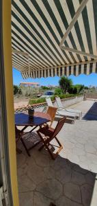un tavolo e delle sedie sotto un ombrellone in un patio di Vivenda Maresol a Sagres