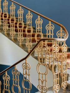 a close up of a gold railing on a staircase at Das Schider - Boutique Apart-Hotel in Bad Gastein