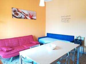 a living room with a pink couch and a table at La Dea del mare in Scilla