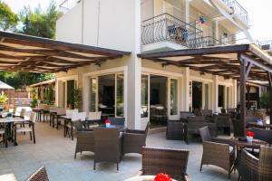 un patio al aire libre con mesas y sillas en Irilena Hotel en Lassi