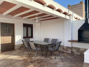 un patio con mesa, sillas y chimenea en Apartamentos Turísticos La Teja, en Arroyo del Ojanco