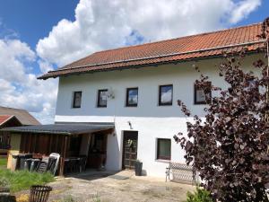 Biały dom z czerwonym dachem w obiekcie Bauernhaus Auberg ganzes Haus w mieście Hutthurm