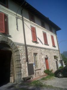 an old stone building with red shutters on it at Antica Casa Fenaroli in Iseo