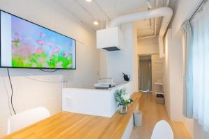sala de estar con TV de pantalla plana en la pared en Feel Asakusa Stay, en Tokio
