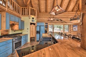 Il comprend une cuisine avec des placards bleus et un plafond en bois. dans l'établissement Spacious, Luxe Cabin with Mtn Views, Sauna and More!, 