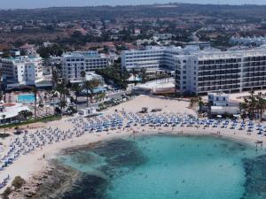 an aerial view of a beach with people and umbrellas at Anonymous Beach Hotel (Adults 16+) in Ayia Napa