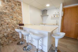 a kitchen with two bar stools and a counter at 2BD-Piscina-Playa-Port Aventura2 in Salou +32 photos