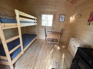 a room with bunk beds and a desk in a cabin at Karhunkierros Cabins & Huts in Salla
