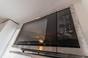 a microwave oven sitting on top of a shelf at Driftwood Haus in Southampton