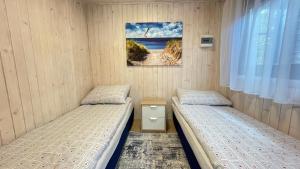 a bedroom with two beds and a picture on the wall at Willa RAFA in Jastarnia
