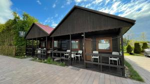 a house with tables and chairs in front of it at Willa RAFA in Jastarnia