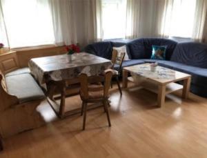 a living room with a table and a blue couch at Bauernhaus Auberg ganzes Haus in Hutthurm