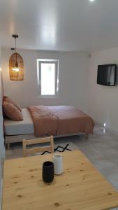 um quarto com uma cama, uma televisão e um piso de madeira em Gîte de l'Automne em Béthisy-Saint-Martin