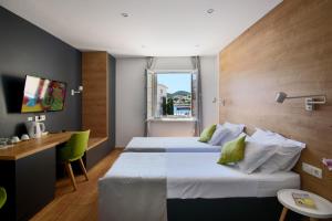 a hotel room with two beds and a desk at Ora Luxury Rooms in Dubrovnik
