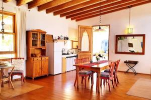 a kitchen with a table and chairs and a kitchen with white appliances at Tranquila Tierra - Eco Retreat Finca Artis Tirma in Tarajalejo