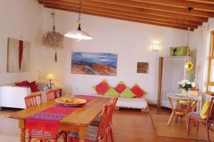 a dining room with a table and a couch at Tranquila Tierra - Eco Retreat Finca Artis Tirma in Tarajalejo +22 photos