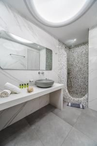 a white bathroom with a sink and a shower at Stavros Villas in Karterados