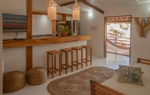 a kitchen with a bar with stools and a table at Swiss Garten Jeri in Jericoacoara