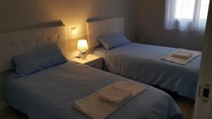 - 2 lits dans une chambre avec des serviettes dans l'établissement GS ALCÁZAR, à Talavera de la Reina