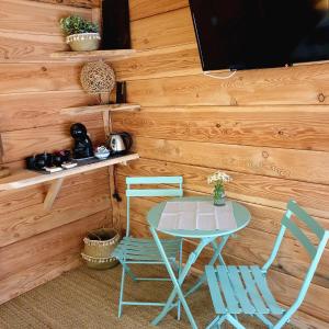 een tafel en twee stoelen en een televisie in een kamer bij La maison basse in Saint-Dalmas-le-Selvage