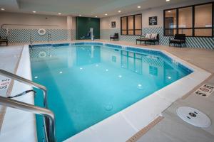 Holiday Inn St Louis - Creve Coeur في سانت لويس: مسبح كبير مع ماء أزرق في غرفة الفندق