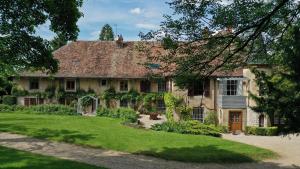 a large stone house with a green yard at Domaine de Bellevue Gîte du Mont Begon in Marnoz