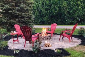 four red chairs sitting around a fire pit at Romantic Golden Spa Suite in Lambton Shores