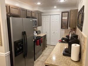 a kitchen with a stainless steel refrigerator and cabinets at Spacious 3 Bedroom 2 bath Condo close to Five-points in Athens in Athens +21 photos