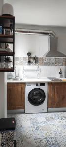 a kitchen with a sink and a washing machine at Apartamentos Serendipia in Santillana del Mar
