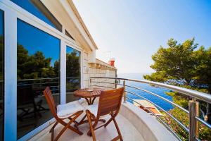 a balcony with a table and two chairs and a lighthouse at Big Blue Apartments in Dubrovnik