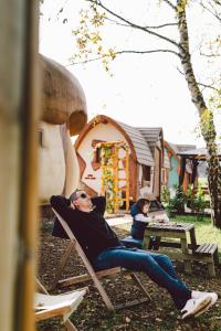 a man laying in a lawn chair in a yard at Glamping Rajska vas in Šentjur