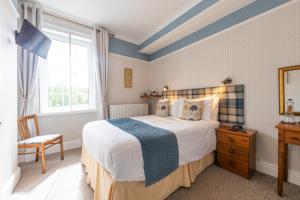 a bedroom with a large bed and a window at Edale House B&B in Parkend
