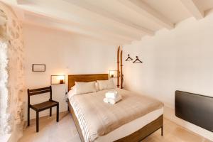 a bedroom with a bed and a chair and a tv at La Maisonnette du Thiou - 50 square meters in the heart of Annecy in Annecy