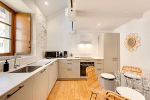 a kitchen with a table and chairs and a sink at La Maisonnette du Thiou - 50 square meters in the heart of Annecy in Annecy