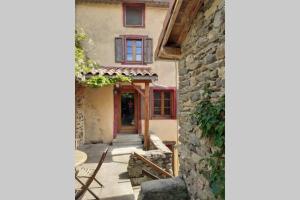 una entrada a una casa con una pared de piedra en Gite La Vigne en Blesle