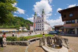 un bâtiment avec une fontaine au milieu d'une ville dans l'établissement Haus Hirzinger, à Brixen im Thale