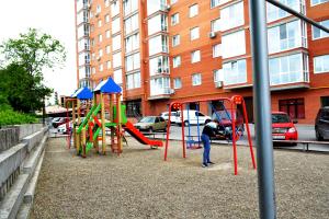 Ein Mann spielt auf einem Spielplatz in der Unterkunft Апартаменты ПРЕМЬЕР in Kamjanez-Podilskyj