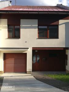 una casa con dos puertas de garaje y un camino de entrada en Řadovka Bílá, en Bílá