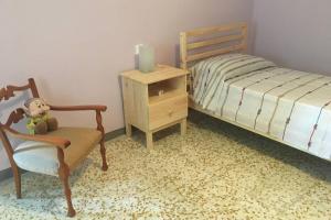 1 dormitorio con 1 cama, 1 silla y 1 mesita de noche en casa vacanze da Anna, en Vacri