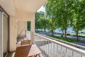 uma varanda com um banco e vista para uma rua em Le Panoramique - Apartment facing the lake em Annecy