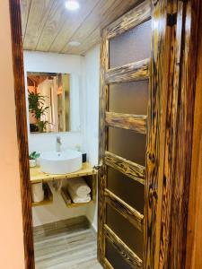 Un baño con lavabo y puerta de madera. en Palmeras del Valle, en Santa Bárbara de Samaná