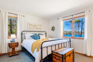 1 dormitorio con 1 cama y 2 ventanas en Vance Lake Retreat, en Manitowish Waters
