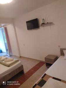 a room with two beds and a tv on the wall at Apartment Chukov in Star Dojran