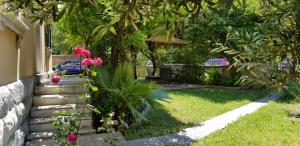 a garden with pink flowers next to a house at Beach City Pearls Apartments in Split