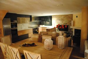 uma cozinha e sala de jantar com uma mesa de madeira e cadeiras em Villa Adilia 