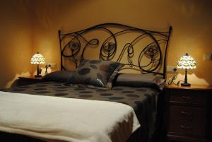 a bedroom with a large bed and two lamps at Villa Adilia 