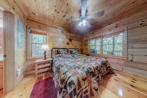 een slaapkamer met een bed en een plafondventilator bij Itterberg Cabin in Blue Ridge