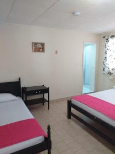 a bedroom with two beds and a table in it at Casa turística Erikmar in Gaira