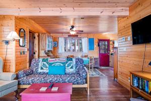 ein Wohnzimmer mit einem Sofa und einem TV in der Unterkunft Bucky's PineIsle Retreat in Three Lakes